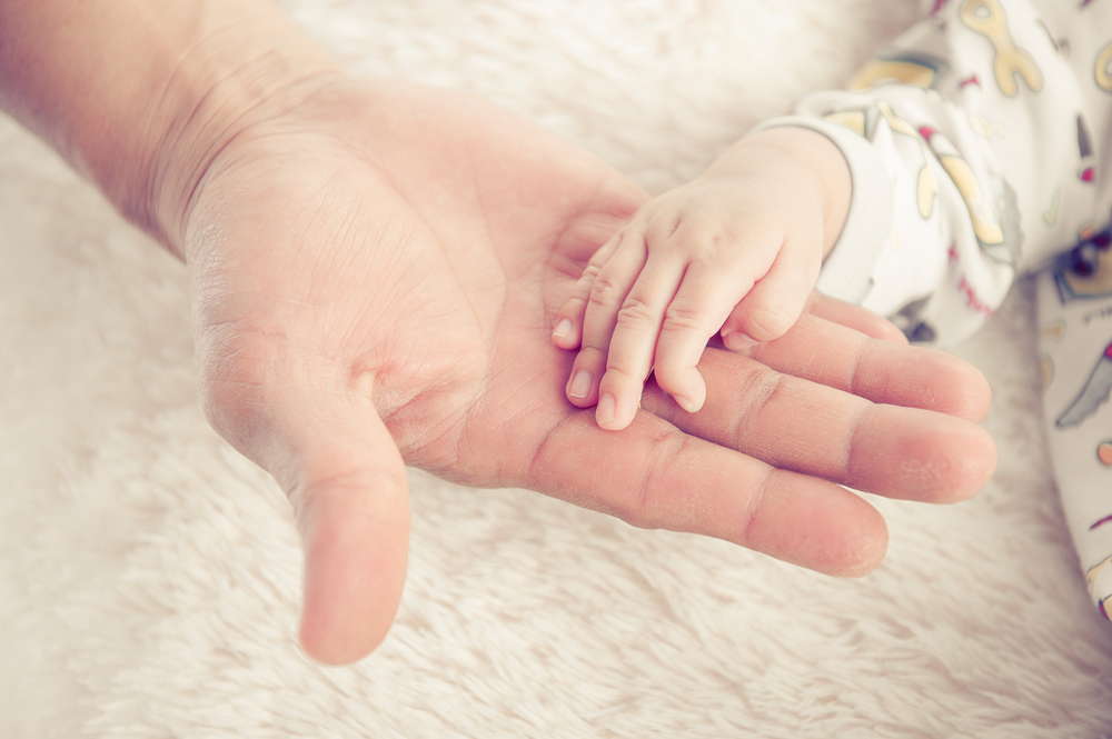 Ръце на възрастен и бебе